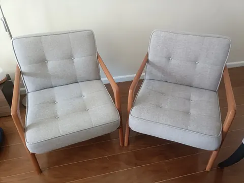 Duas poltronas cinza com braços de madeira higienizadas